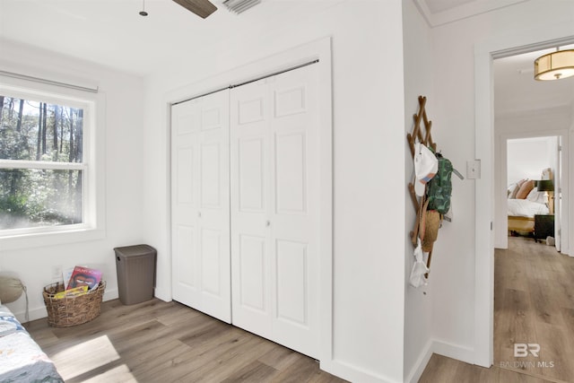 bedroom featuring a closet, baseboards, and wood finished floors