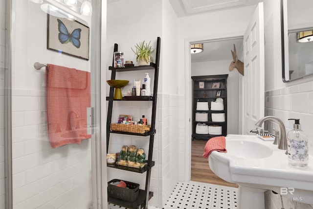 bathroom featuring a sink, a wainscoted wall, and tile walls