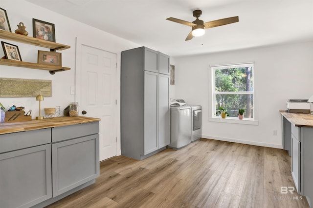 kitchen with gray cabinets, independent washer and dryer, light wood finished floors, and wooden counters