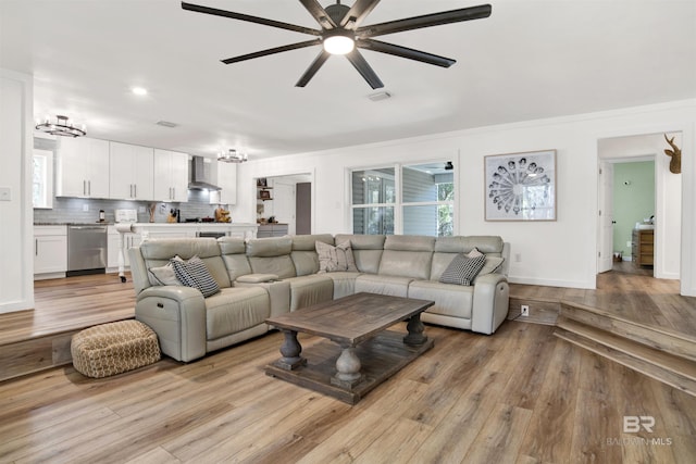 living room with visible vents, ceiling fan, light wood-style flooring, and baseboards