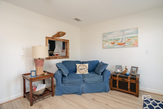 living area featuring wood finished floors, visible vents, and baseboards