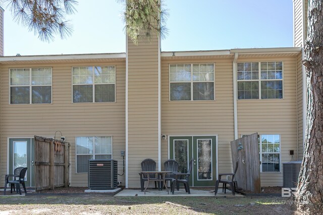 rear view of property with cooling unit, a patio, and a chimney