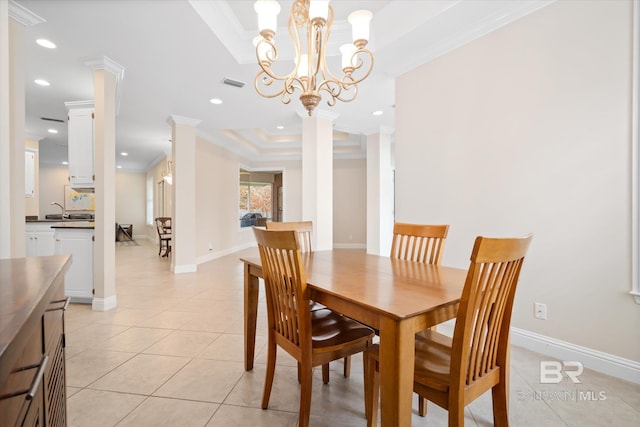 tiled dining area with sink, crown molding, decorative columns, and a raised ceiling