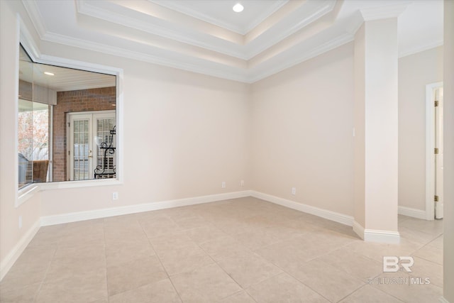 tiled spare room with ornamental molding and a raised ceiling