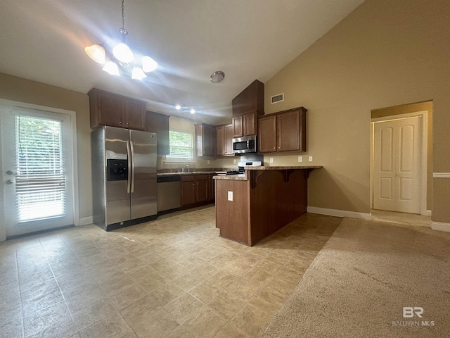 8185 Savage Loop, Theodore, AL 36582 - kitchen featuring stainless steel appliances, a peninsula, vaulted ceiling, a breakfast bar area, and decorative light fixtures