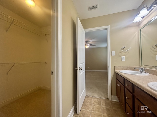 8185 Savage Loop, Theodore, AL 36582 - bathroom with double vanity, a spacious closet, a ceiling fan, and tile patterned floors
