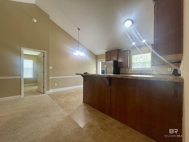 8185 Savage Loop, Theodore, AL 36582 - kitchen with stainless steel fridge, a peninsula, a kitchen breakfast bar, pendant lighting, and dark countertops