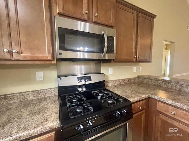 8185 Savage Loop, Theodore, AL 36582 - kitchen featuring appliances with stainless steel finishes, brown cabinets, and light countertops