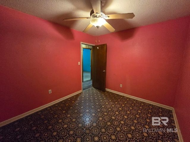 spare room featuring a ceiling fan, baseboards, a textured ceiling, and carpet flooring