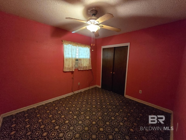 unfurnished bedroom featuring a ceiling fan, a closet, baseboards, a textured ceiling, and carpet flooring