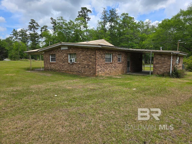 view of side of property featuring a lawn, an attached carport, cooling unit, and brick siding