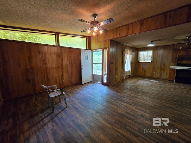 interior space with a ceiling fan, a textured ceiling, and dark wood-style floors