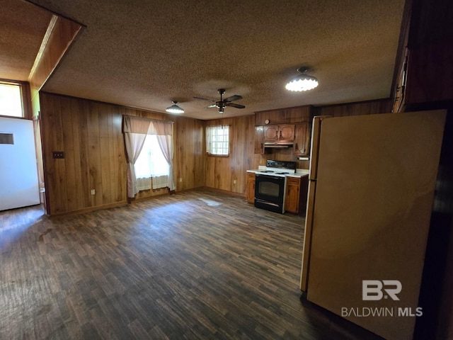 kitchen featuring freestanding refrigerator, a textured ceiling, dark wood-style floors, and electric range oven