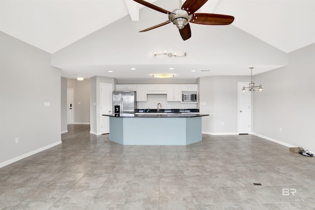 kitchen featuring decorative light fixtures, stainless steel appliances, beam ceiling, a kitchen island with sink, and white cabinets