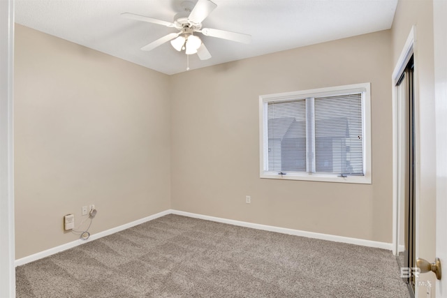 empty room featuring ceiling fan and light carpet