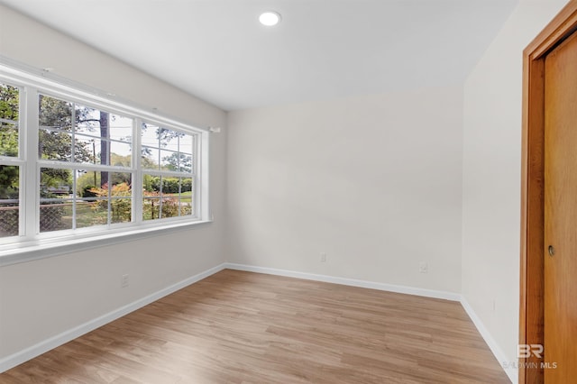 empty room with recessed lighting, light wood-style flooring, and baseboards