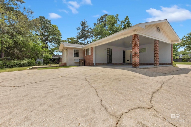 ranch-style house with brick siding, an attached carport, and concrete driveway
