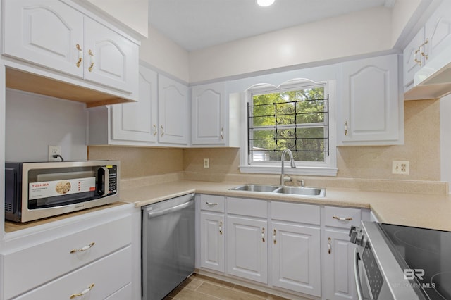 kitchen featuring white cabinetry, stainless steel appliances, and a sink
