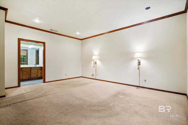 carpeted empty room featuring crown molding