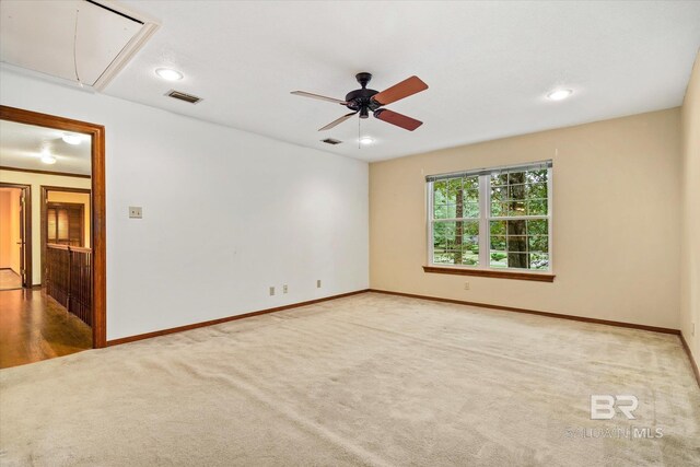 empty room featuring ceiling fan and light carpet