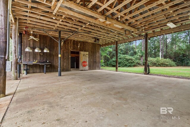 miscellaneous room featuring concrete floors and wooden walls