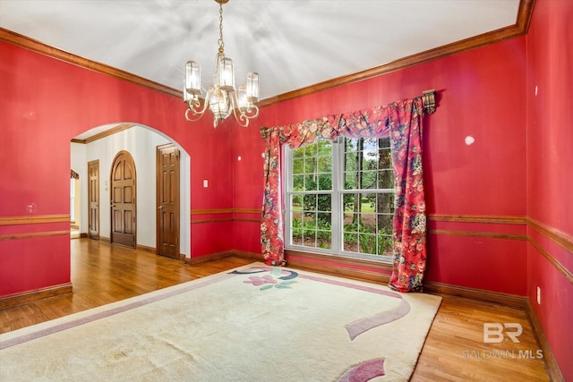 3761 Winford Rd, Mobile, AL 36619 - unfurnished dining area featuring baseboards, ornamental molding, wood finished floors, arched walkways, and an inviting chandelier