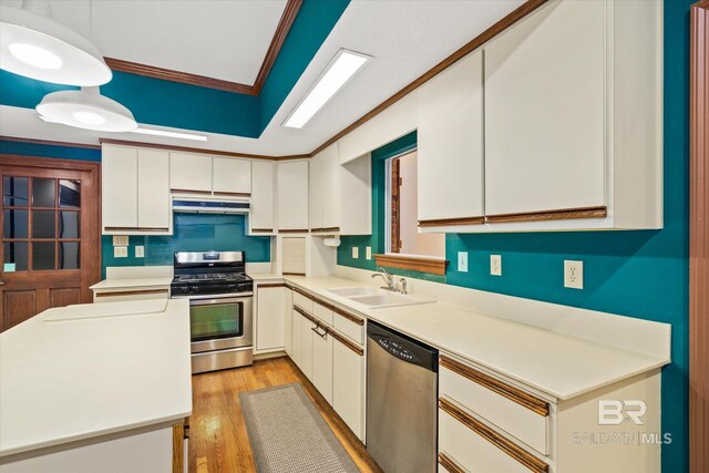 kitchen featuring light hardwood / wood-style floors, stainless steel appliances, ornamental molding, sink, and white cabinets