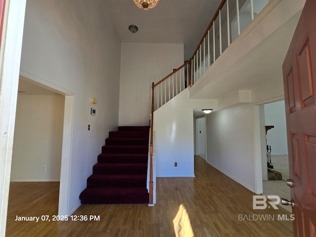 staircase featuring hardwood / wood-style floors and a high ceiling