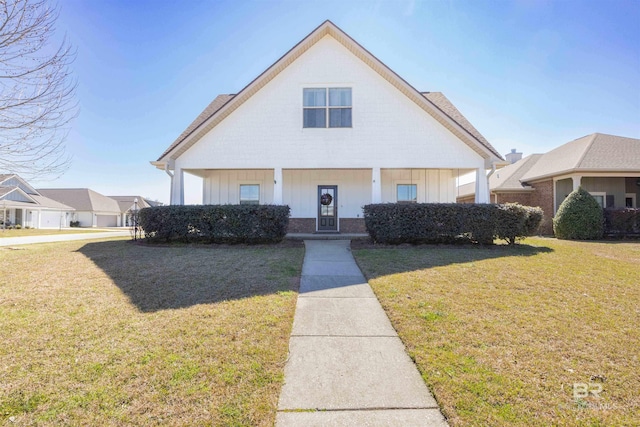 8856 Asphodel Ln, Daphne, AL 36526 - bungalow featuring board and batten siding, a front lawn, a porch, and brick siding
