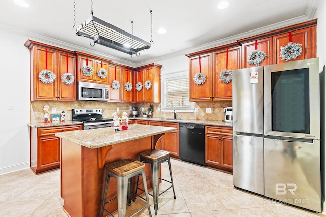 kitchen featuring a center island, ornamental molding, stainless steel appliances, and light tile patterned floors