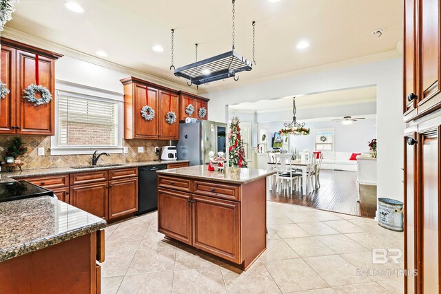 kitchen featuring a center island, black appliances, ceiling fan with notable chandelier, sink, and light hardwood / wood-style flooring