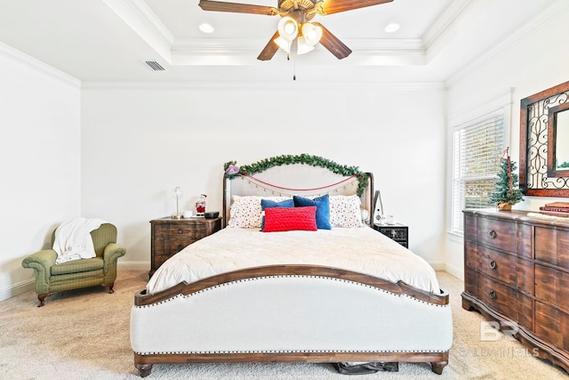 bedroom featuring light carpet, a tray ceiling, ceiling fan, and ornamental molding