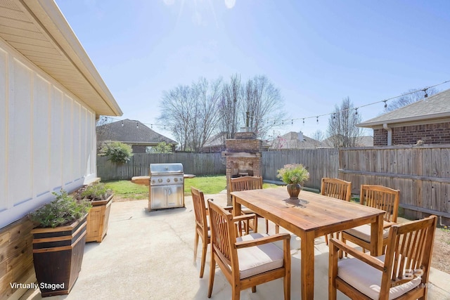 8856 Asphodel Ln, Daphne, AL 36526 - fenced backyard featuring an outdoor fireplace, a patio, and outdoor dining area