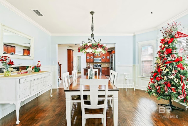 dining area with crown molding and dark wood-type flooring