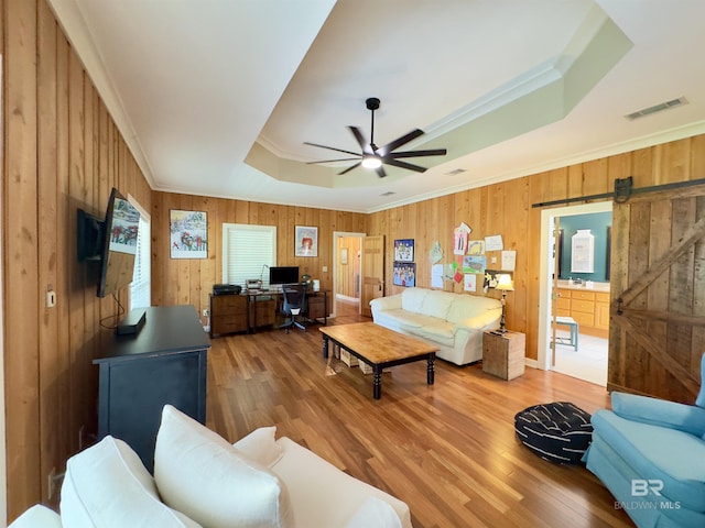 51600 State Highway 59, Bay Minette, AL 36507 - living room featuring a tray ceiling, an office area, wood finished floors, wooden walls, and a ceiling fan