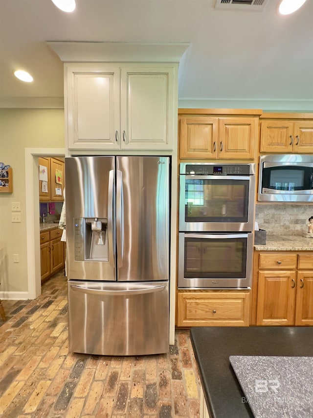 51600 State Highway 59, Bay Minette, AL 36507 - kitchen with appliances with stainless steel finishes, brick floors, light stone countertops, recessed lighting, and decorative backsplash