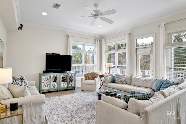 living room with ceiling fan, a healthy amount of sunlight, and ornamental molding