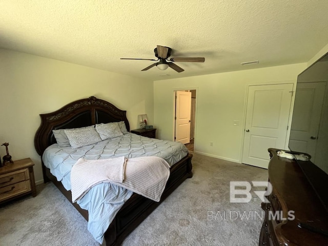 bedroom with a textured ceiling, carpet flooring, baseboards, and a ceiling fan