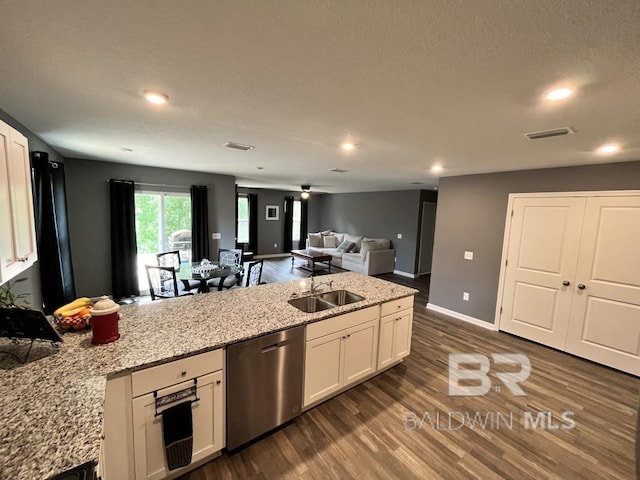 kitchen featuring a sink, dark wood-type flooring, visible vents, white cabinets, and stainless steel dishwasher