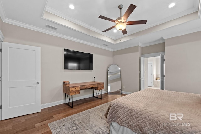 bedroom with ornamental molding, dark hardwood / wood-style floors, and a raised ceiling