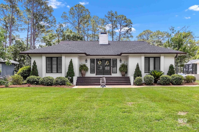 607 Wedgewood Dr, Gulf Shores, AL 36542 - view of front of property with brick siding, a chimney, a front yard, and roof with shingles