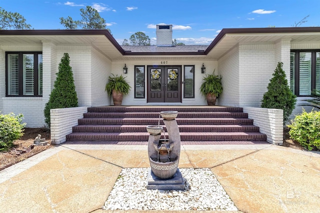 607 Wedgewood Dr, Gulf Shores, AL 36542 - property entrance with brick siding, french doors, and a chimney