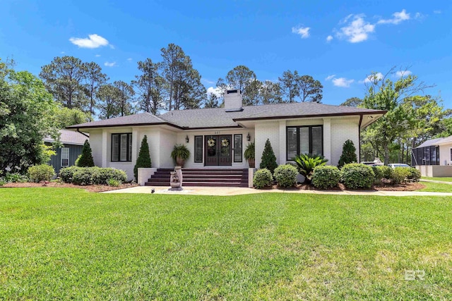 607 Wedgewood Dr, Gulf Shores, AL 36542 - view of front of home with brick siding, a front lawn, a chimney, and roof with shingles