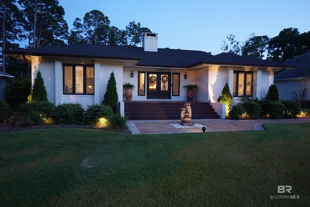 607 Wedgewood Dr, Gulf Shores, AL 36542 - single story home with brick siding, a front yard, a chimney, and french doors