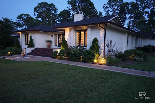 607 Wedgewood Dr, Gulf Shores, AL 36542 - view of front of property with a front yard, brick siding, and a chimney