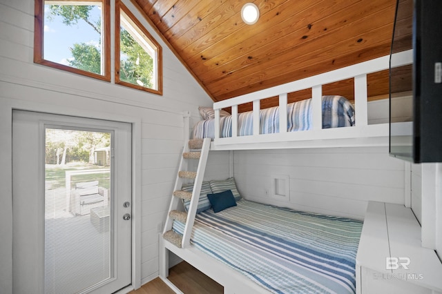 bedroom featuring vaulted ceiling, wooden ceiling, and wooden walls