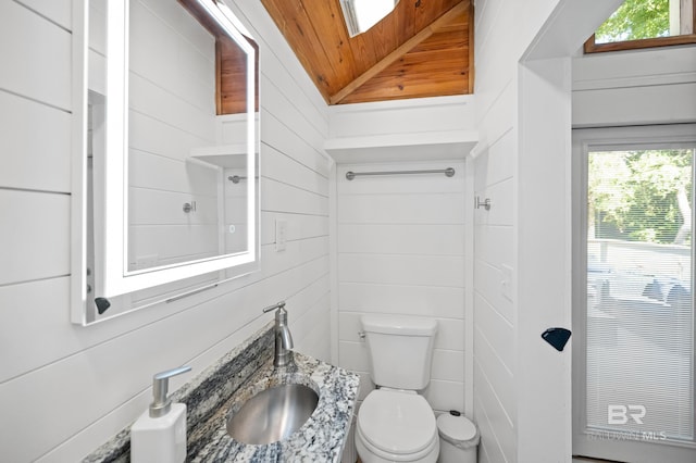 bathroom with lofted ceiling, wood ceiling, wooden walls, and toilet