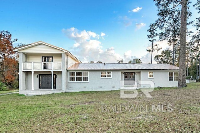 back of house featuring a yard and a balcony