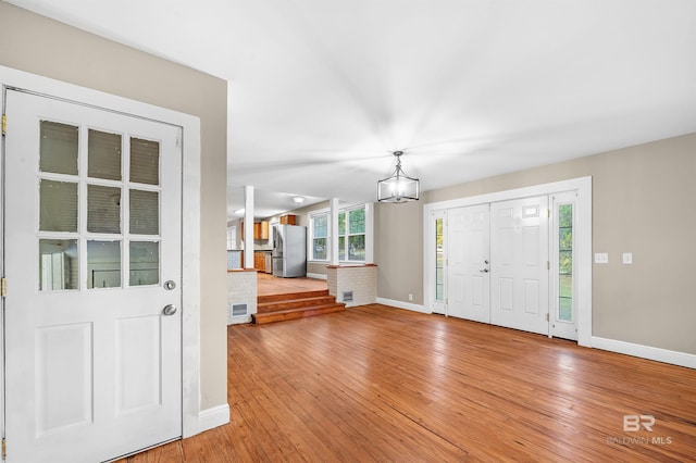 entrance foyer with hardwood / wood-style flooring and an inviting chandelier