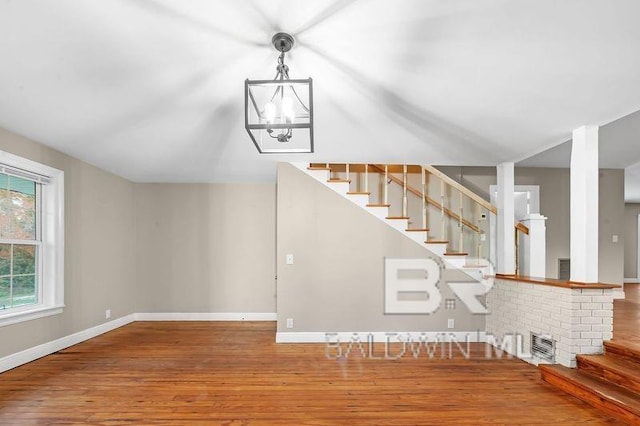 staircase with hardwood / wood-style flooring and a notable chandelier